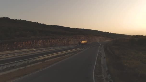 Drönare efter stor lastbil på tom motorväg vid solnedgången — Stockvideo