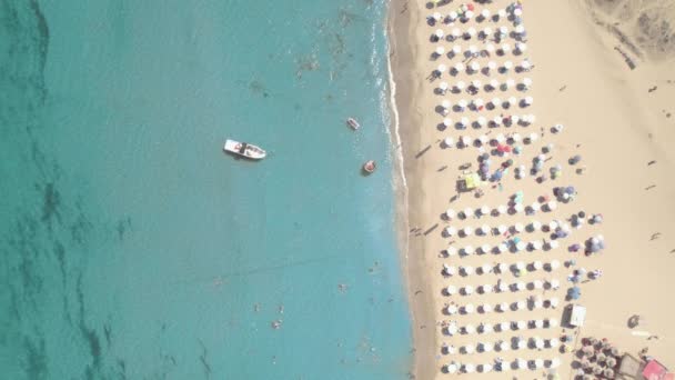 有雨伞船的沙滩和在海湾中游泳的人的俯瞰 — 图库视频影像
