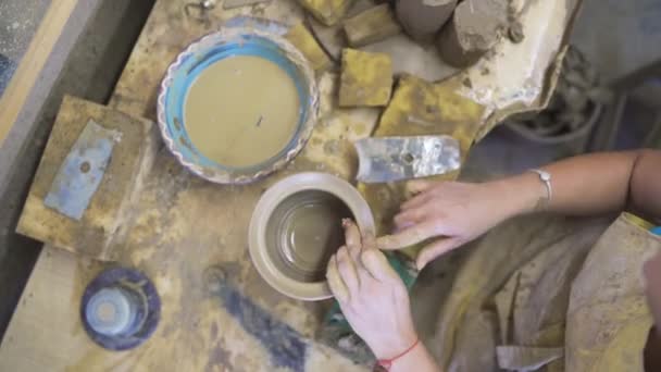 Високий кут зору жіночого гончарного формування коричневої глини в керамічній майстерні — стокове відео