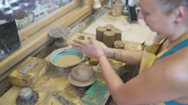 Ceramista femminile aprendo una palla di argilla sulla ruota — Video Stock