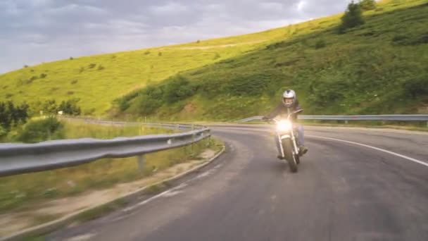 Hombre a caballo motocicleta en carretera de asfalto curva con rural — Vídeos de Stock