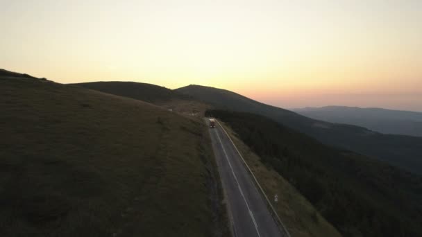 Вид з повітря Вантажівка з причепом на вечірній дорозі в горах на заході сонця — стокове відео