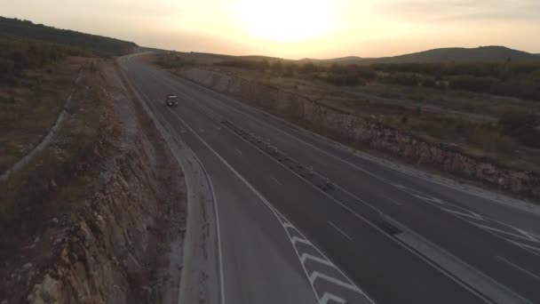 Luchtfoto van het werk vrachtwagen rijden op lege snelweg bij zonsondergang — Stockvideo