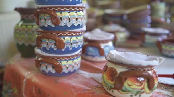 형형색색의 도기 항아리, 그릇 및 컵들이 들어 있는 선반들 과 선반들을 클로즈업함 — 비디오