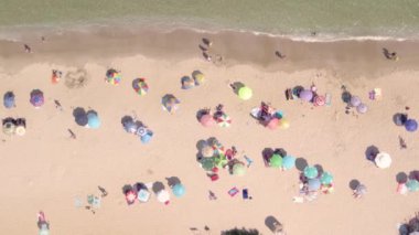 Sıcak yaz gününde deniz sahilinde güneşlenen insanların hava manzarası.