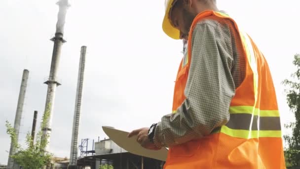 Uomo ingegnere architetto supervisore di costruzione in cappello duro e giubbotto lavorare con disegno cianografia. — Video Stock