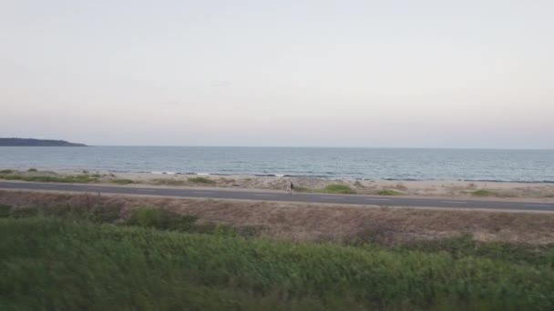 Hombre soltero en bicicleta en el camino de la playa temprano en la mañana — Vídeos de Stock