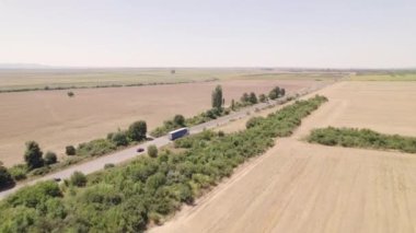 Arka planda buğday tarlası olan nakliye kamyonu olan otoyol. 