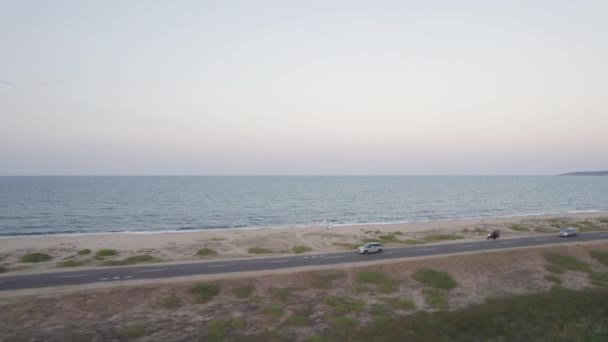 Vista aérea de carros dirigindo em uma estrada pelo mar. — Vídeo de Stock