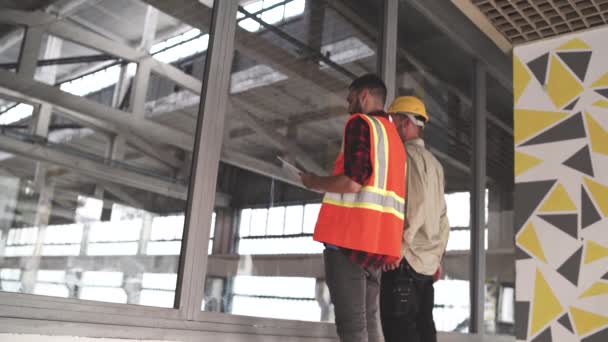Ingeniero de equipos mirando el plano en un sitio de construcción — Vídeo de stock
