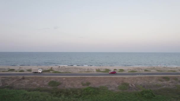 Vue latérale de la voiture rouge conduite sur la route de la plage — Video