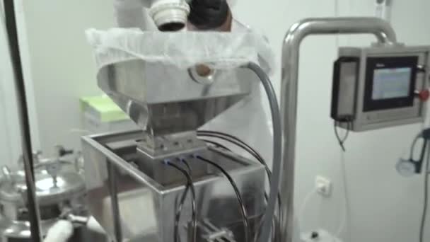 Scientifique avec des gants noirs travaillant sur une machine complexe et y versant de l'huile de chanvre — Video