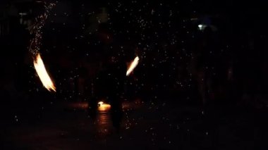 Troyan, Bulgaristan-06 09 2021: Enerjik erkek alev dansçısı her yerde kıvılcımlar saçarak ateş savuruyor