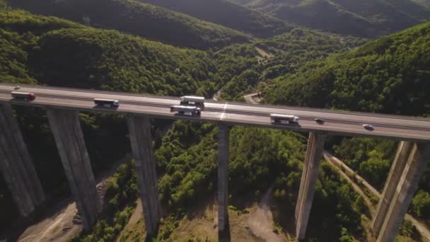 多くの貨物輸送トラックがオンに駆動と忙しい高速道路の高架橋橋の空中ドローンビュー — ストック動画