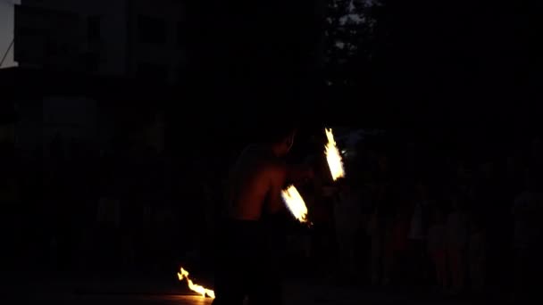 Троян, Болгария-06 09 2021: Человек крутит огненные палки ночью на фестивале — стоковое видео