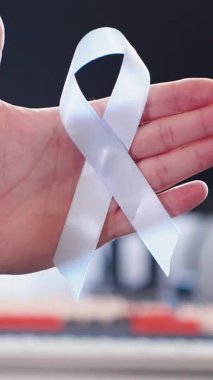 Prostat kanseri önleme ve Movember farkındalığı için kullanılan mavi kurdelenin sembolik yakın çekimi. Umut desteği ve birlik kavramı.