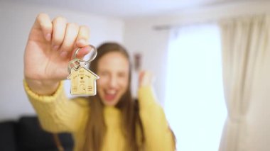 Neşeli kadın yeni evinin anahtarını gösteriyor. Heyecan verici başarı ve dönüm noktası anı. Gayrimenkul ve yaşam tarzı içeriği için mükemmel..