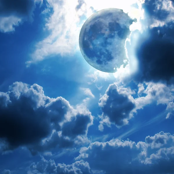 La luna piena splende attraverso le nuvole nel cielo notturno Immagine Stock