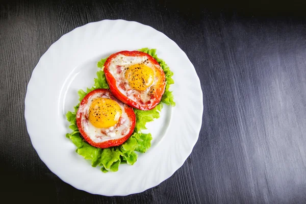 Ovos em uma salada verde em uma pimenta vermelha, comida — Fotografia de Stock