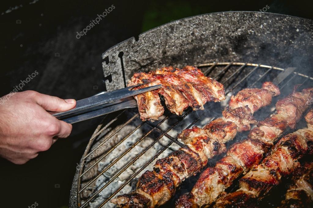 Chef a la parrilla con salchichas de barbacoa en una brasa ...