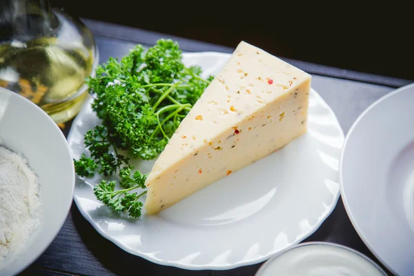 Piece of cheese, herbs, food ingredients — Stock Photo, Image