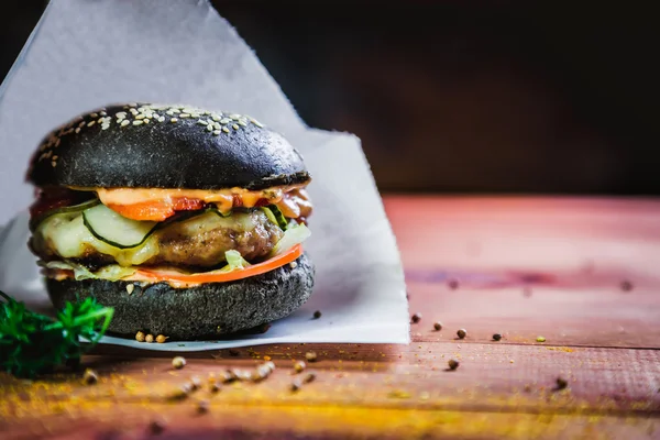 Бургер с черной булочкой, вкусная еда — стоковое фото