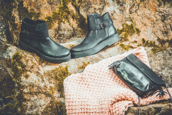 Black leather boots and black handbag on granite and moss, female soda — Stock Photo, Image