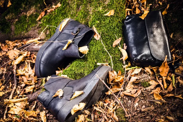 Black leather boots and black handbag on moss, female soda — Stock Photo, Image