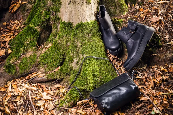 Bottes en cuir noir et sac à main noir sur mousse, soude féminine — Photo