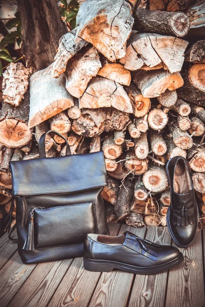 Zapatos de cuero negro y una mochila sobre un fondo de madera, zapatos de mujer — Foto de Stock