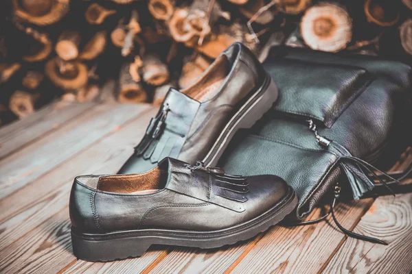 Zapatos de cuero negro y una mochila sobre un fondo de madera, zapatos de mujer — Foto de Stock