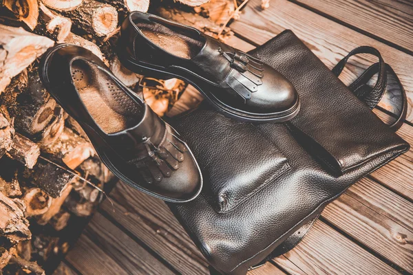 Μαύρα δερμάτινα παπούτσια και ένα σακίδιο σε φόντο ξύλινη, Γυναικεία παπούτσια — Φωτογραφία Αρχείου