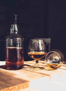 Barda bir şişe brendi ve iki bardak alkol.