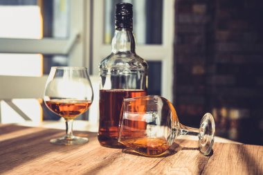 Barda bir şişe brendi ve iki bardak alkol.