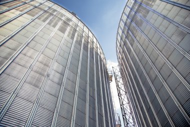 Background, metal barrels granaries on the sky background clipart