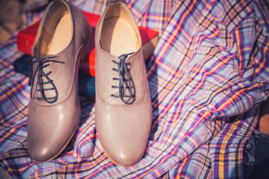 Bayan deri ayakkabı bağcıklarımı ile üzerinde kareli bir masa örtüsü vardır