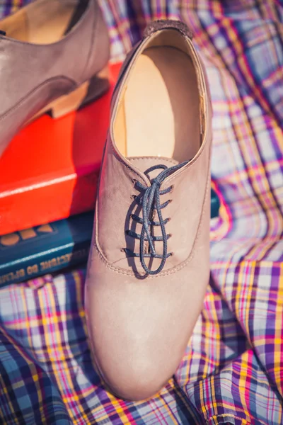 Chaussures en cuir pour femmes avec lacets sont sur une nappe à carreaux — Photo