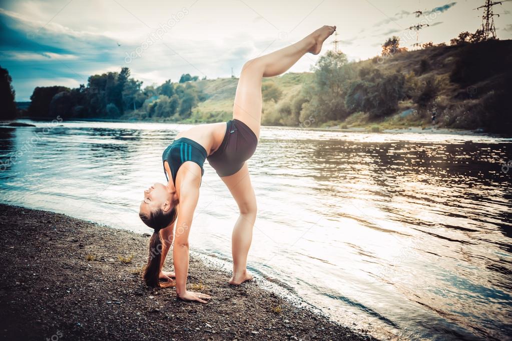 Sports girl doing exercises on the banks of rivers