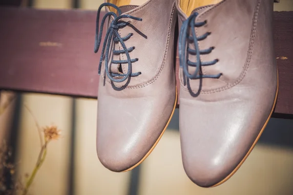 Zapatos de mujer colgados de una tabla de madera — Foto de Stock