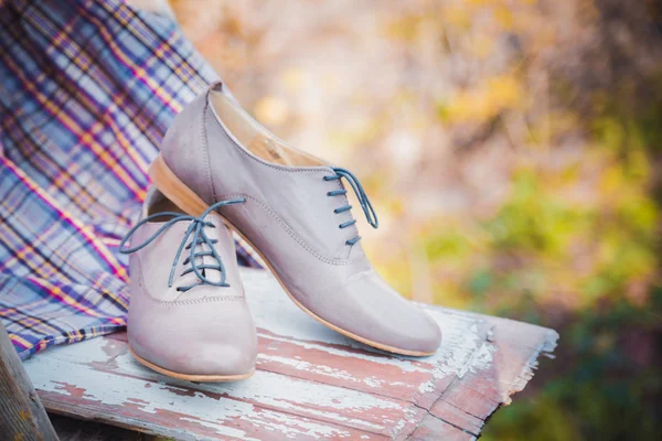 Chaussures en cuir pour femmes avec lacets sont sur une nappe à carreaux — Photo