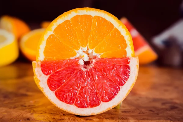 Arancio e pompelmo a metà taglio sul tavolo — Foto Stock