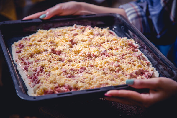 girl prepares a pizza, sausage, cheese filling