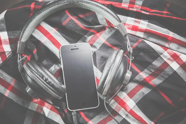 Telefoon en de hoofdtelefoon op een shirt, luisteren naar muziek — Stockfoto