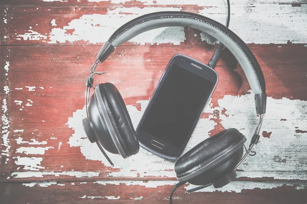 音楽を聴くヘッドフォンと携帯電話のビンテージ写真 — ストック写真