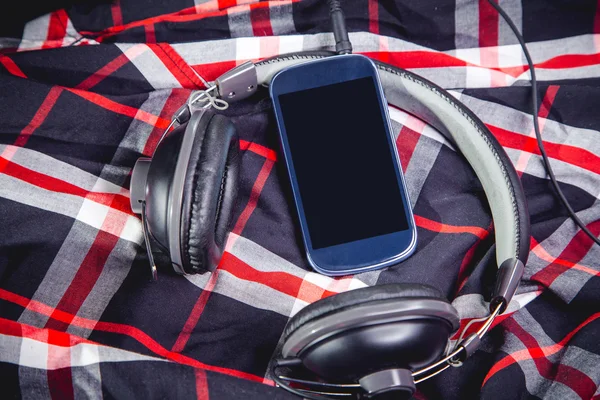 Teléfono y auriculares en una camisa, escuchando música — Foto de Stock