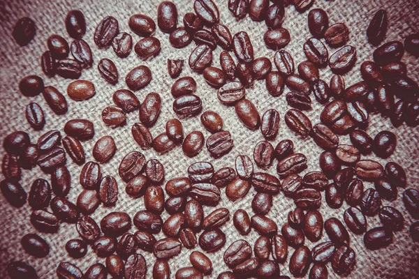 Verstreute Kaffeekörner in einer Tasse auf einem hölzernen Hintergrund — Stockfoto