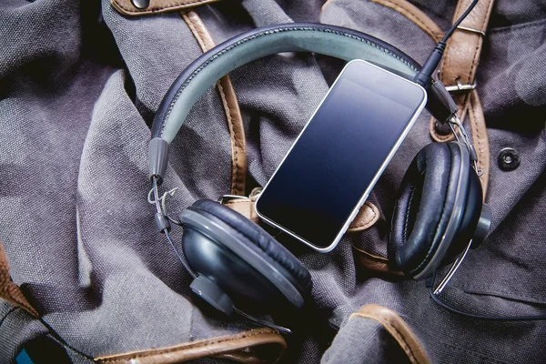 Muziek op de reis, de telefoon en de hoofdtelefoon op een rugzak — Stockfoto