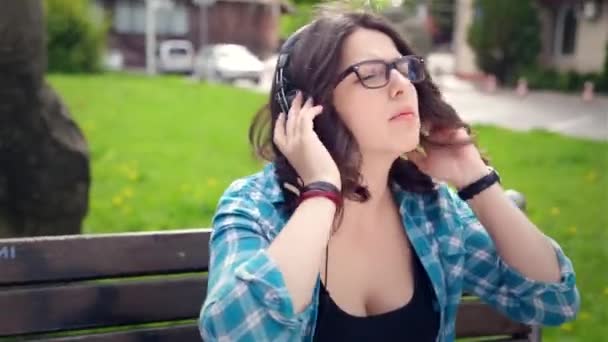 Hermosa chica escuchando música en auriculares estéreo — Vídeo de stock