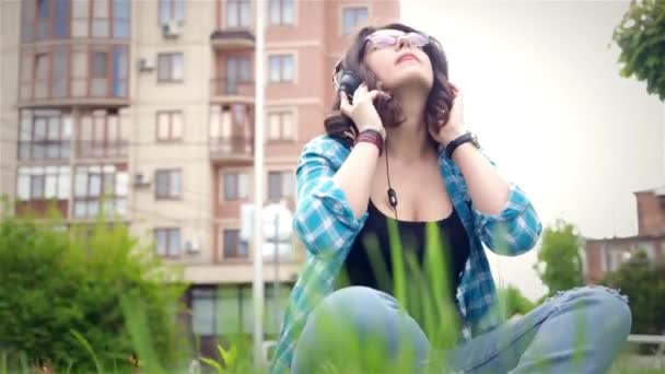 Hermosa chica escuchando música en auriculares estéreo — Vídeos de Stock