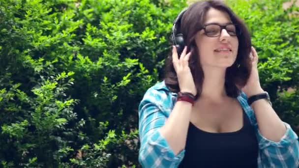 Hermosa chica escuchando música en auriculares estéreo — Vídeos de Stock